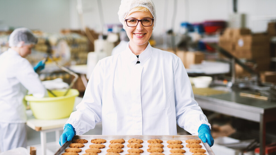 Employee holding tray with baked goods